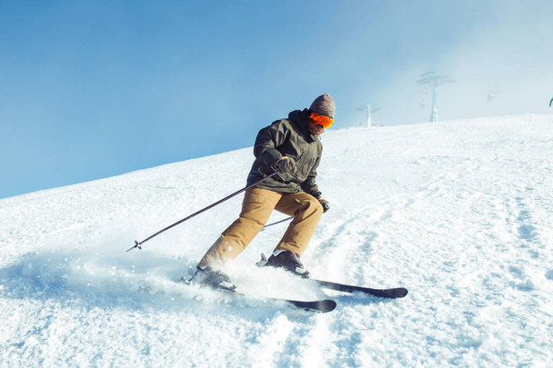 Nice young man skiing in the mountains. Skiing in the snowy mountains, Winter is coming, snowfall. Active lifestyle in winter. Ski resort season is open. Ski equipment, trail. Extreme winter sports. - Photo, image