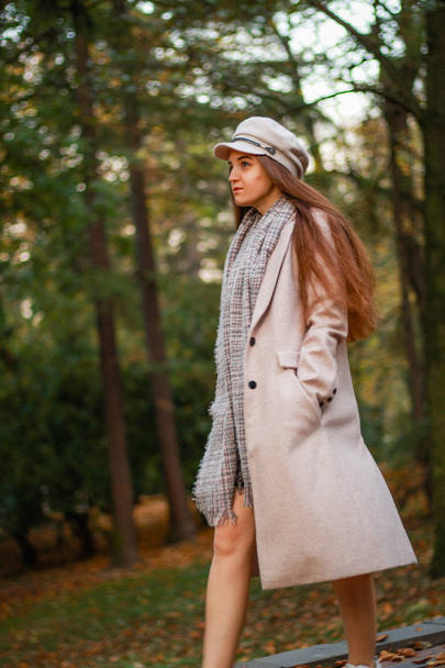 Autumn girl portraits. Beige coat, hat, white sneakers. Successf - Foto, Bild