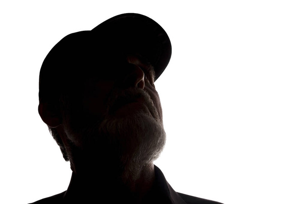 Old man in peaked cap, side view - dark close-up silhouette - Φωτογραφία, εικόνα