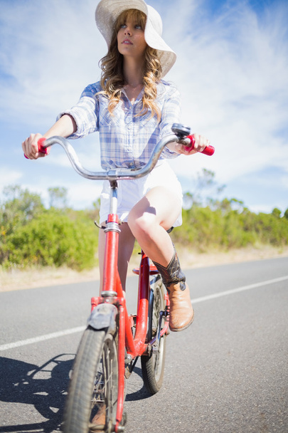 Thoughtful young woman posing while riding bike - Foto, immagini