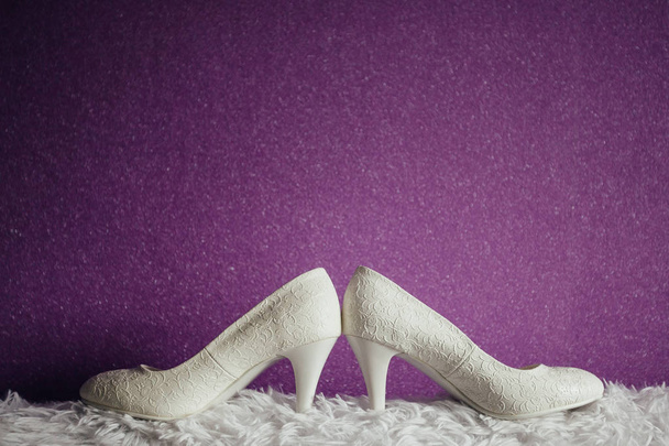 Wedding rings lying on white shoes - Foto, Imagen