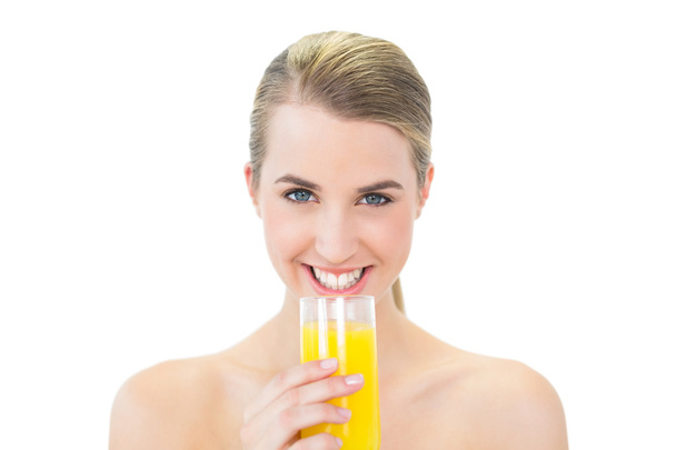 Smiling attractive blonde holding glass of orange juice - Foto, Imagen