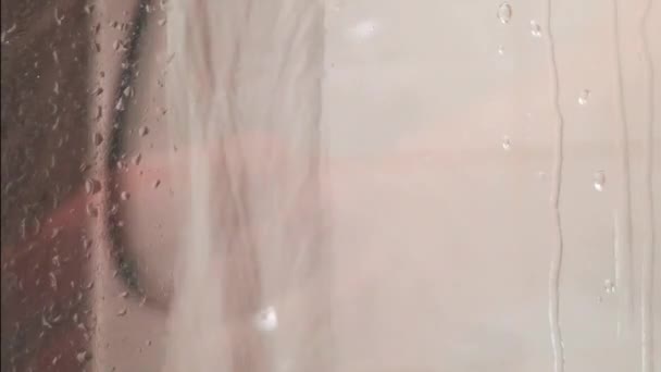 En la ducha, el agua que cae a través de un vaso humeante de la mampara de ducha
 - Metraje, vídeo