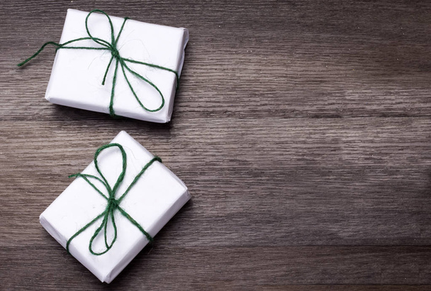 two gifts wrapped in white paper on a blackboard background - Photo, Image