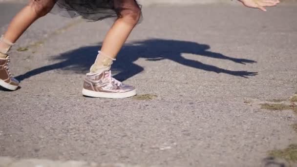 close-up. teenage girl legs in pink shiny sneakers. girl is making a gymnastic exercise, a cartwheel - Video