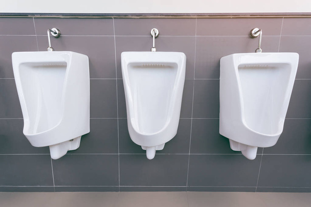 Beyaz porselen pisuarların sıralı olduğu erkekler tuvaleti. Modern temiz pu - Fotoğraf, Görsel