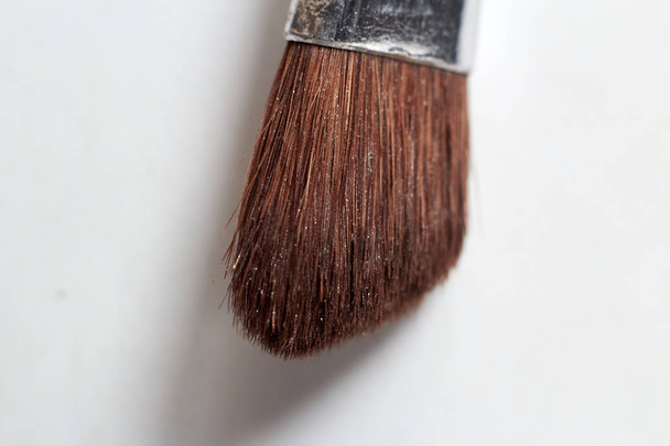 A makeup brush on a white background helps to apply makeup on the face. - Foto, Bild