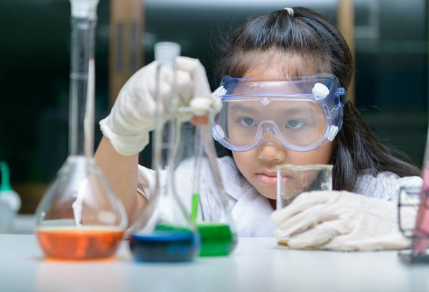  Malá holčička nosí bezpečnostní brýle dělat experiment  - Fotografie, Obrázek
