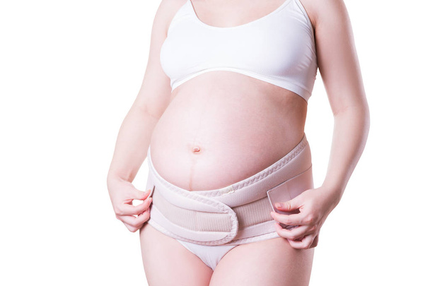 Pregnant woman with orthopedic support belt, isolated on white background - Photo, Image