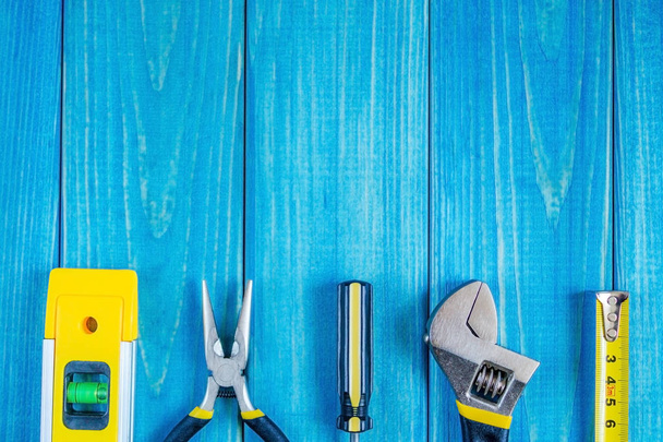 Tools for master builder and accessories on blue wooden vintage background - Photo, Image