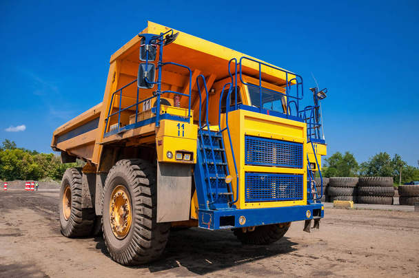 lourd camion à benne jaune au poste de réparation à la journée ensoleillée sans nuages
 - Photo, image