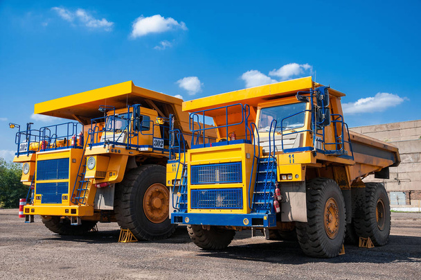 heavy yellow dump truck at repair station at sunny cloudless day - 写真・画像