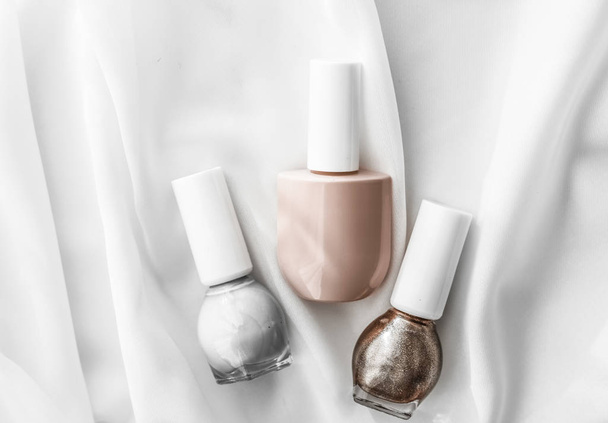 Nail polish bottles on silk background, french manicure products - Фото, зображення