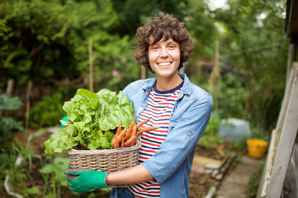 Portret van lachende boer met groente in mand - Foto, afbeelding