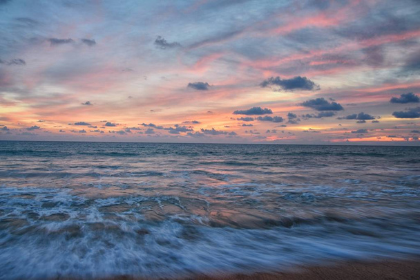 Coucher de soleil sur la plage de Phuket, ciel nuageux et coloré au crépuscule reflétant le sable regardant l'océan Indien, la Thaïlande, l'Asie
. - Photo, image
