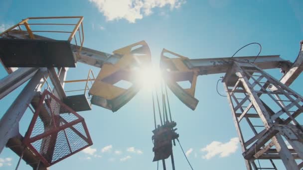 pumpjacks στο πεδίο του πετρελαίου κατά μπλε ουρανό με λευκά σύννεφα - Πλάνα, βίντεο