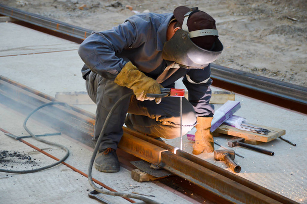 Worker welds a tram rail joint - 写真・画像