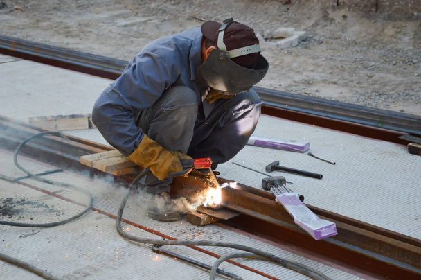 Un travailleur soude un joint de rail de tramway
 - Photo, image