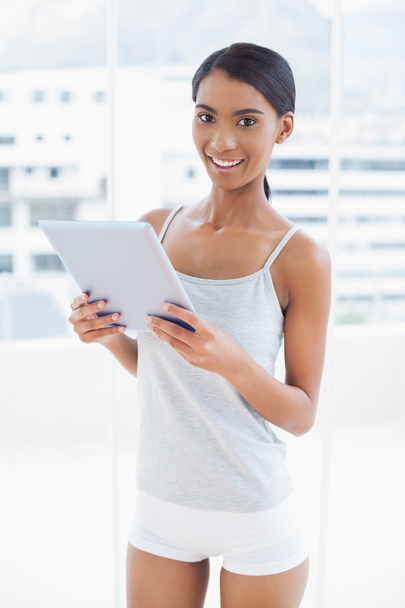Smiling sporty model holding digital tablet - Foto, Bild