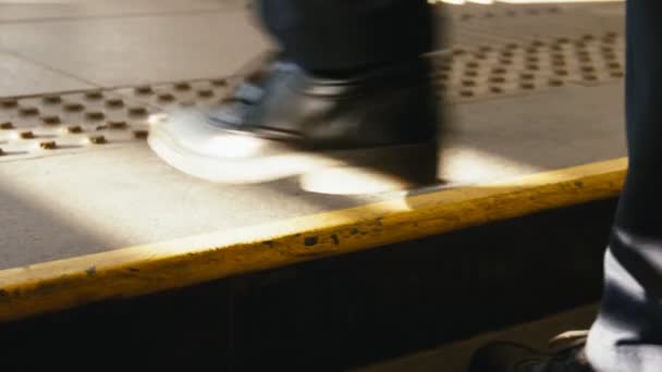 muž v černých botách jde nahoru kovové schody na slunci detailní up - Záběry, video