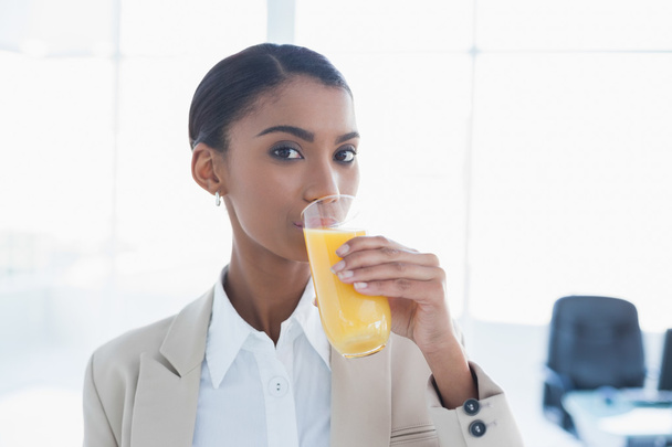 Smiling elegant businesswoman drinking orange juice - Foto, Imagem