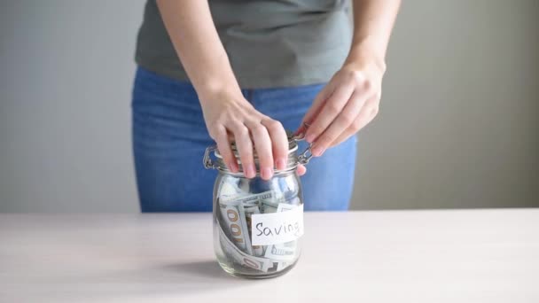 Vrouw neemt geld van de spaarpot met inscriptie Saving. Crisis en faillissementsconcept - Video