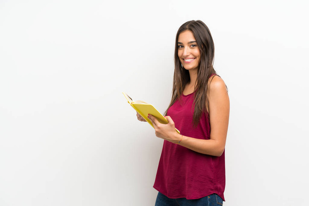 Молодая женщина на изолированном белом фоне держит и читает книгу
 - Фото, изображение