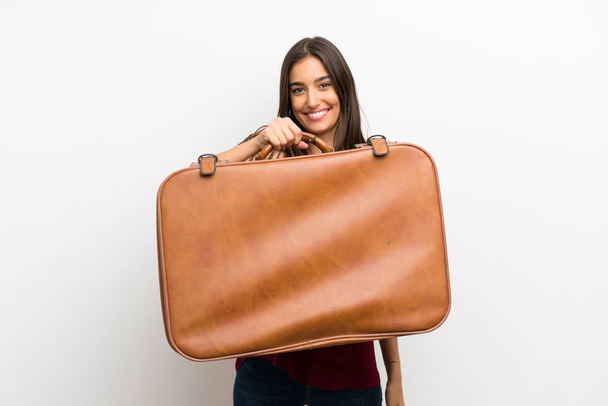 Young woman over isolated white background holding a vintage briefcase - Foto, immagini