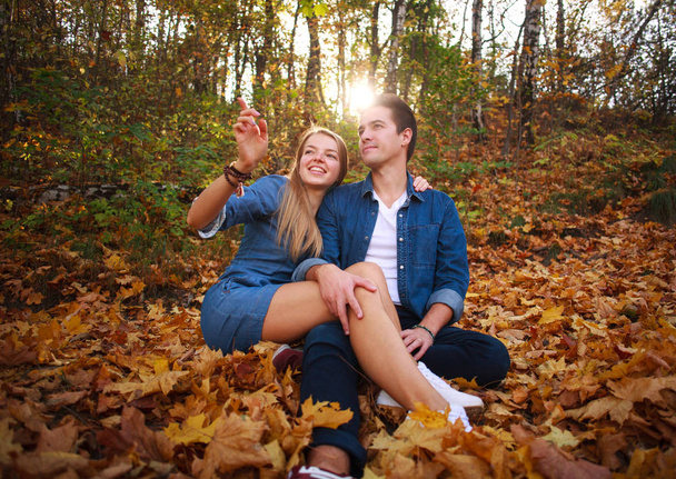 Loving happy young couple in forest park in autumn on nature - Photo, Image