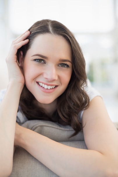Close up on smiling cute woman lying on a cosy couch - Foto, Bild
