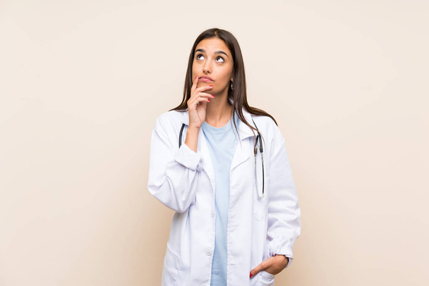 Young doctor woman over isolated background thinking an idea - Foto, Imagem