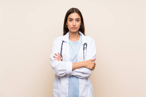 Joven doctora sobre fondo aislado manteniendo los brazos cruzados
 - Foto, imagen