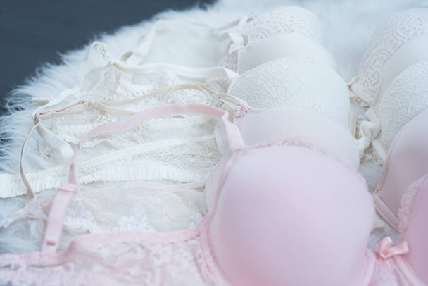 Details of bodices with lace on white fur. Pastel shades. Fashionable concept of lingerie. Close up. - 写真・画像