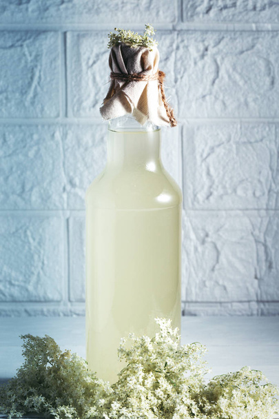 Starší limonáda - zdravý a osvěžující nápoj. Detailní záběr domácího bezinkového sirupu v láhvi se staršími květy. Letní nápoj Hugo Champagne nápoj s bezinkovým sirupem, mátou  - Fotografie, Obrázek