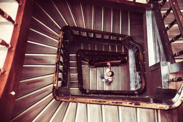 Kız spiral bir merdivene tırmanıyor. Tam üstte - Fotoğraf, Görsel