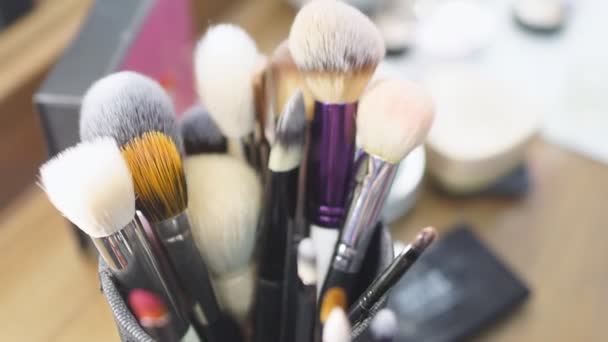 Conjunto de pinceles y herramientas de maquillaje profesional en una mesa
 - Imágenes, Vídeo
