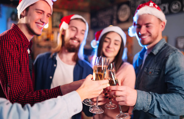 New year glasses for champagne in the hands of friends. Christmas New Year's toast. Friends With Drinks Enjoying Cocktail Party. Christmas New Year's toast. Celebreating christmas and new year. - 写真・画像