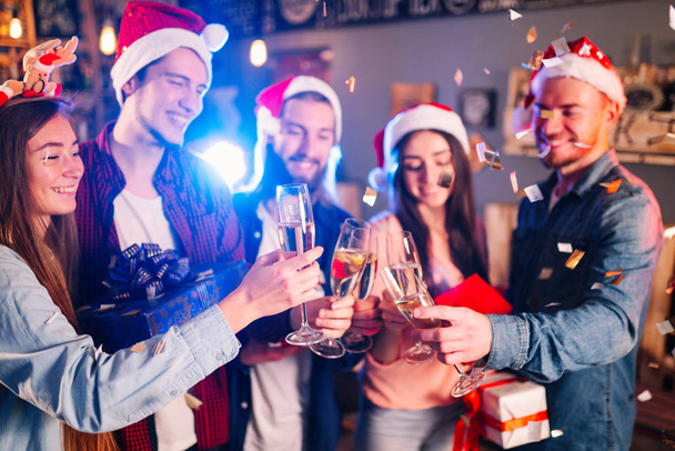 Neujahrsgläser für Champagner in den Händen von Freunden. Anstoßen auf das neue Jahr. Freunde mit Drinks genießen Cocktailparty. Anstoßen auf das neue Jahr. Weihnachten und Neujahr feiern. - Foto, Bild