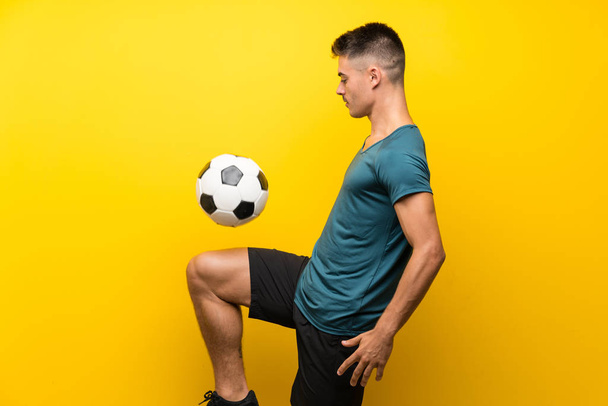 Красивий молодий футболіст чоловік над ізольованим жовтим тлом
 - Фото, зображення