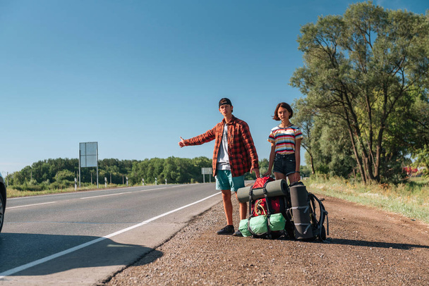 Hitchhiking couple. Backpackers on road - Photo, Image