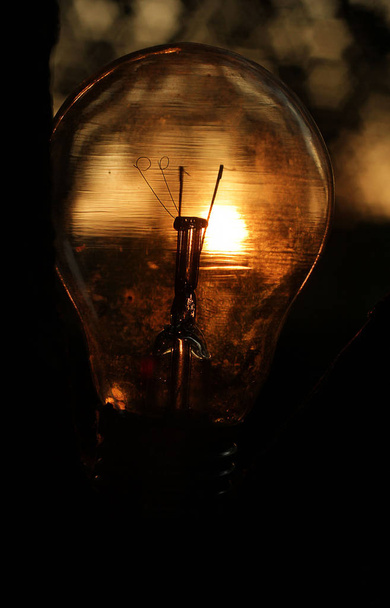 Lâmpada incandescente na rua da noite com reflexão solar
 - Foto, Imagem