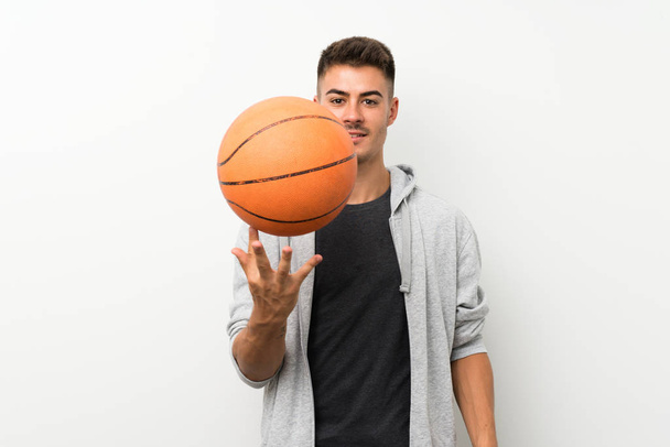 Άθλημα άνθρωπος πάνω από απομονωμένο λευκό τοίχο με μπάλα του μπάσκετ - Φωτογραφία, εικόνα