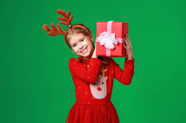 . happy funny child girl in red Christmas reindeer costume with  - Fotó, kép