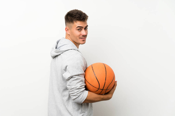 Hombre deportivo sobre pared blanca aislada con pelota de baloncesto
 - Foto, imagen