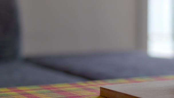 filmische 4k "horizontale Pfanne" Aufnahme von Obstteller mit bunten frischen Früchten: Orange auf Holzteller mit karibischer Madras-Tischdecke - Filmmaterial, Video