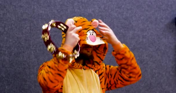 Mann Schauspieler in einem Tigergewand bereitet seine Schauspielerei mit einem Tamburin vor - Filmmaterial, Video