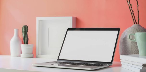 Минимальное рабочее место с открытым чистым экраном ноутбука с копировальными и офисными принадлежностями
  - Фото, изображение