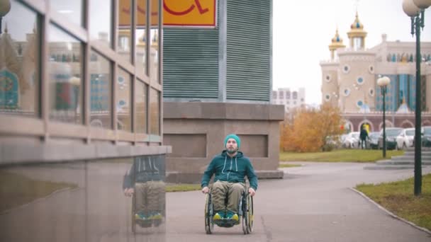 Tekerlekli sandalyedeki engelli adam engelli işaretini görür ve özel bir yere doğru hareket eder. - Video, Çekim