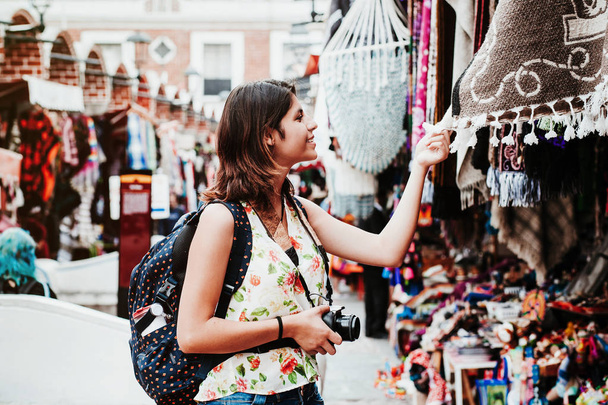 Latin woman backpacker shopping in a Tourist Market in Mexico City, Mexican Traveler in America - Foto, Bild