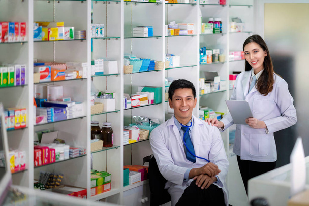 Asian Pharmacist man and girl sit in  medicinen room in her pham - Фото, зображення